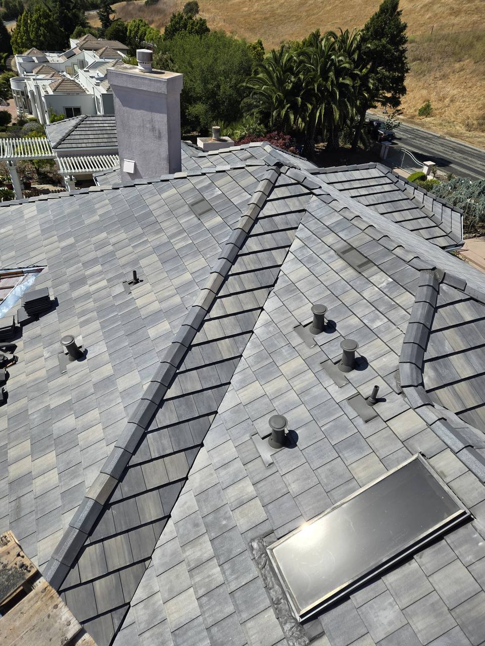 Finished Newpoint concrete roof tile installation with skylight and chimney detail